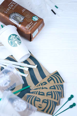 KHARKOV, UKRAINE - MARCH 15, 2021: Starbucks production on white wooden table. Starbucks Corporation is multinational chain of coffeehouses and roastery reserves headquartered in Seattle, Washingtonのeditorial素材
