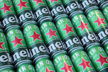 KHARKOV, UKRAINE - JULY 31, 2021: Green tin cans of Heineken pale lager beer produced by the Dutch...