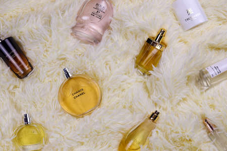 KHARKOV, UKRAINE - JANUARY 12, 2021: Many perfume bottles with famous brand names lies on fluffy beige plaid. luxury perfume setのeditorial素材