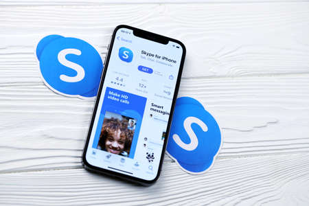 KHARKOV, UKRAINE - MARCH 5, 2021: Skype icon and application from App store on iPhone 12 pro display screen on white wooden tableのeditorial素材