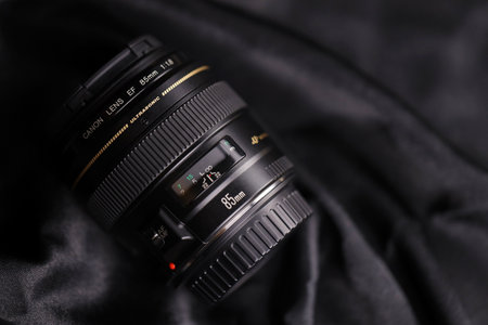 KHARKOV, UKRAINE - JANUARY 21, 2021: Canon EF 85mm 1.8 lens on black fabric background. Detailed photo of Canon brand productのeditorial素材