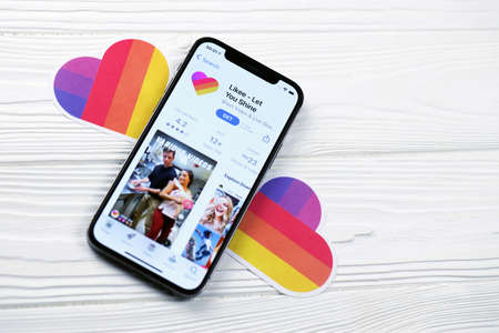 KHARKOV, UKRAINE - MARCH 5, 2021: Likee icon and application from App store on iPhone 12 pro display screen on white wooden tableのeditorial素材