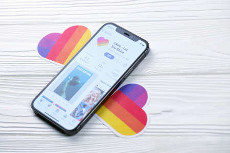 KHARKOV, UKRAINE - MARCH 5, 2021: Likee icon and application from App store on iPhone 12 pro display screen on white wooden tableのeditorial素材