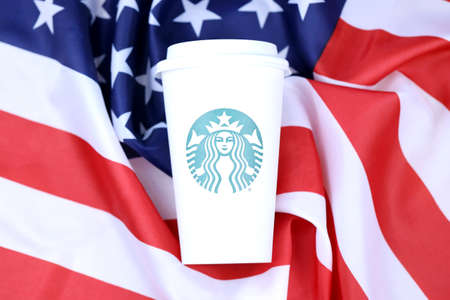 KHARKOV, UKRAINE - MARCH 15, 2021: Starbucks cup on US flag. Starbucks Corporation is a multinational chain of coffeehouses and roastery reserves headquartered in Seattle, Washingtonのeditorial素材