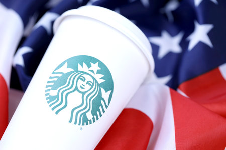 KHARKOV, UKRAINE - MARCH 15, 2021: Starbucks cup on US flag. Starbucks Corporation is a multinational chain of coffeehouses and roastery reserves headquartered in Seattle, Washingtonのeditorial素材