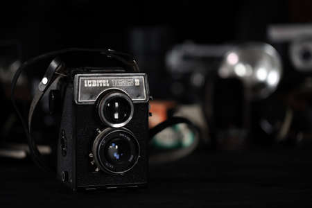 KHARKOV, UKRAINE - APRIL 27, 2021: Lubitel 166b and 2 Film photo camera and another old retro photo equipment on black wooden table in photographer darkroom. Photographic gear from soviet union timesのeditorial素材
