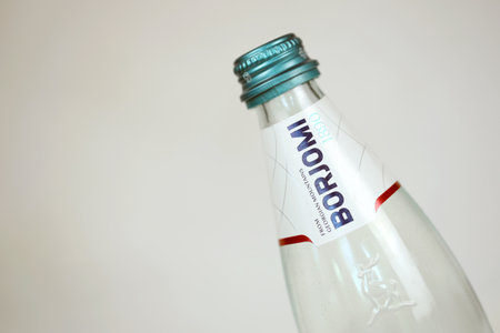 KHARKOV, UKRAINE - JULY 2, 2021: Glass of Borjomi brand of naturally carbonated mineral water from springs in the Borjomi Gorge of central Georgiaのeditorial素材