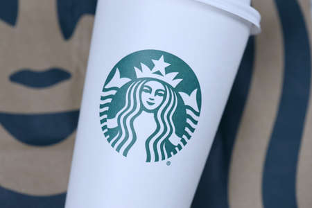 KHARKOV, UKRAINE - MARCH 15, 2021: Starbucks cup with green logo. Starbucks Corporation is a multinational chain of coffeehouses and roastery reserves headquartered in Seattle, Washingtonのeditorial素材