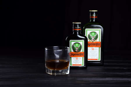 KHARKOV, UKRAINE - DECEMBER 3, 2020: Jagermeister cold macerated elixir bottle on dark black background. Elite alcohol productionのeditorial素材