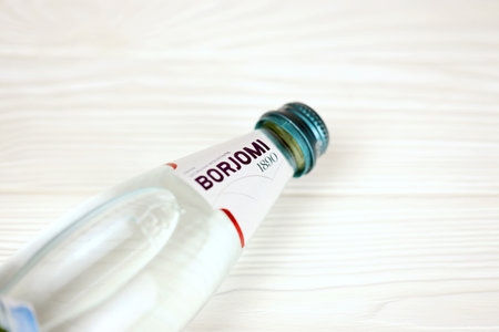 KHARKOV, UKRAINE - JULY 2, 2021: Glass of Borjomi brand of naturally carbonated mineral water from springs in the Borjomi Gorge of central Georgiaのeditorial素材