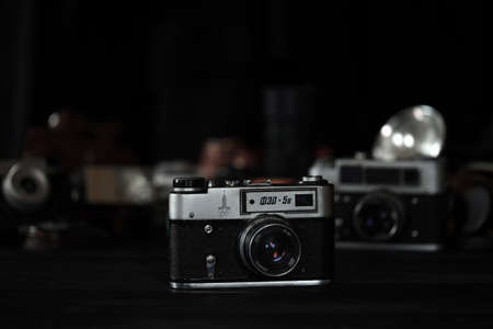 KHARKOV, UKRAINE - APRIL 27, 2021: Fed 4 and 5b Film photo camera and another old retro photo equipment on black wooden table in photographer darkroom. Photographic gear from soviet union timesのeditorial素材