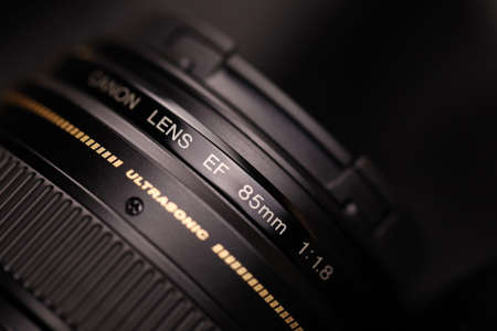 KHARKOV, UKRAINE - JANUARY 21, 2021: Canon EF 85mm 1.8 lens on black fabric background. Detailed...