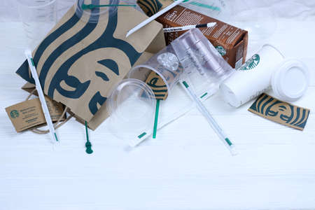 KHARKOV, UKRAINE - MARCH 15, 2021: Starbucks disposable used production on white wooden table....