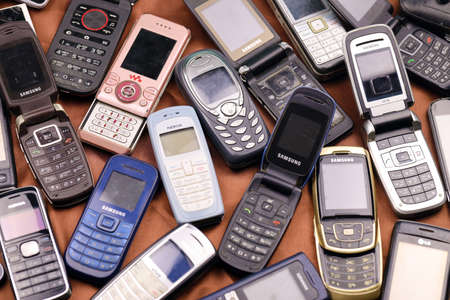 KHARKIV, UKRAINE - DECEMBER 16, 2021: Some old used outdated mobile phones from 90s-2000s period. Recycling electronics in the market cheapのeditorial素材