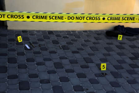 Crime scene tape for covering the area cordon. Yellow tape with blurred forensic law enforcement...