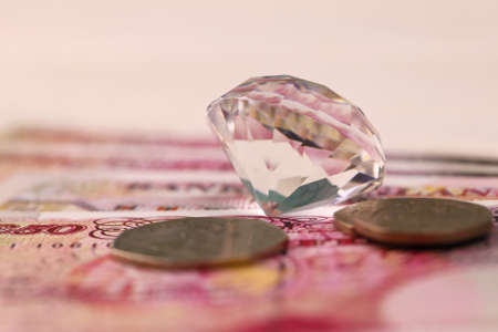UK money bills with large diamond close up. Big amount of United Kingdom pounds and huge transparent...