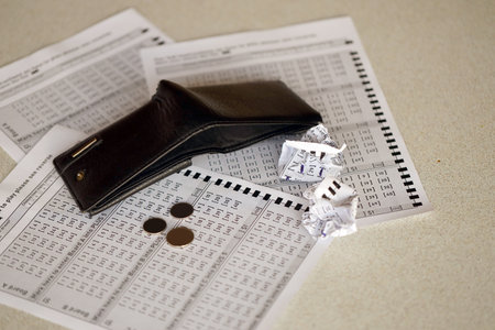 Crumpled lottery tickets and empty purse as symbol of losing the lottery game. Unlucky gambling results. Misfortune and money spendingの写真素材