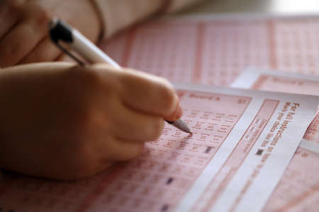 Filling out a lottery ticket. A young woman plays the lottery and dreams of winning the jackpot....