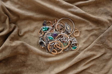 Bunch of stolen jewelry on military uniform cloth fabric. Looting by Russian soldiers in the...