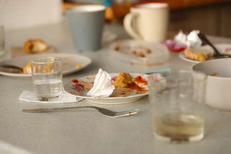 Empty dirty plates with spoons and forks on the table after meal. Banquet ending concept. Unwashed...