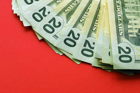 Big amount of old twenty dollar bills on bright red background. Money earnings, payday or tax paying period conceptの写真素材