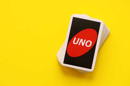 TERNOPIL, UKRAINE - MAY 15, 2022: Many colorful UNO game cards on yellow background close up. UNO is an American shedding-type card game that is played with a specially printed deckのeditorial素材