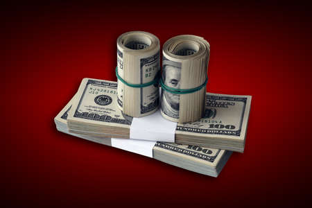 Bundle of US dollar bills on crimson red background. Pack of american money with high resolution on...