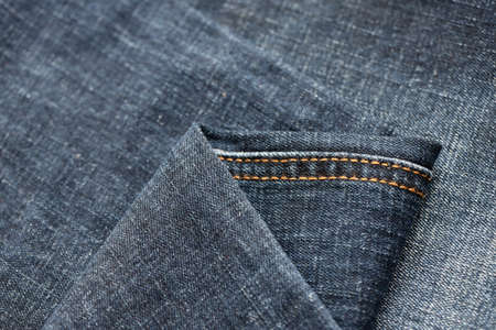 Detailed abstract texture of dark blue denim cloth. Background image of old used denim trousers...