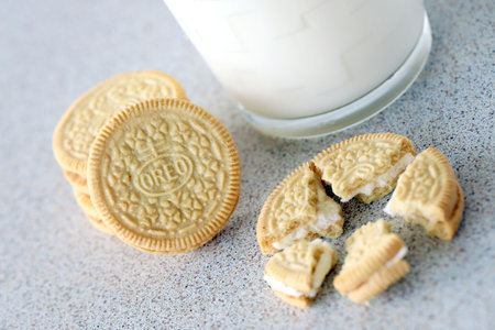 TERNOPIL, UKRAINE - MAY 28, 2022: Oreo golden crispy cookies with glass of milk on white background. The brand Oreo is owned by american company Mondelez internationalのeditorial素材
