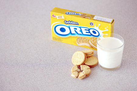 TERNOPIL, UKRAINE - MAY 28, 2022: Oreo golden crispy cookies with glass of milk on white background....