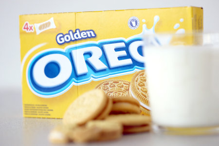 TERNOPIL, UKRAINE - MAY 28, 2022: Oreo golden crispy cookies with glass of milk on white background. The brand Oreo is owned by american company Mondelez internationalのeditorial素材