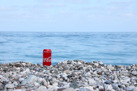 ANTALYA, TURKEY - MAY 18, 2021: Original Coca Cola red tin can lies on small round pebble stones close to sea shore. Coca-cola on turkish beach stonesのeditorial素材
