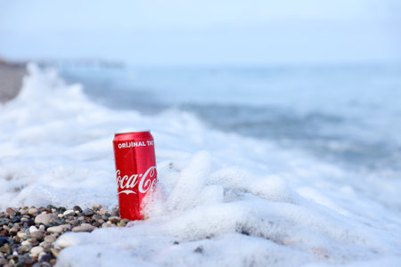 ANTALYA, TURKEY - MAY 18, 2021: Original Coca Cola red tin can lies on small round pebble stones close to sea shore. Coca-cola on turkish beach stonesのeditorial素材