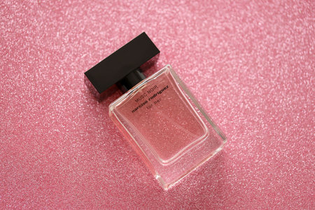 TERNOPIL, UKRAINE - SEPTEMBER 2, 2022 Narciso Rodriguez Musc Noir perfume bottle on shiny glitter background in pink and purple colorsのeditorial素材