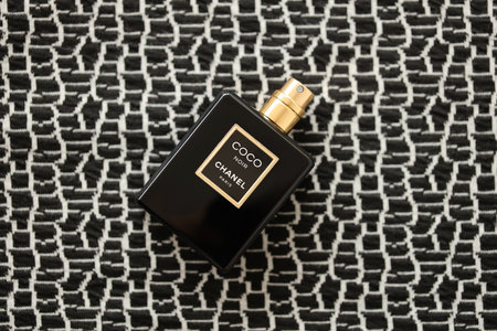 TERNOPIL, UKRAINE - SEPTEMBER 2, 2022 Coco Noir Chanel Paris worldwide famous french perfume black bottle on old plaid with monochrome patternのeditorial素材
