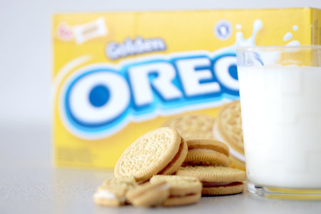 TERNOPIL, UKRAINE - MAY 28, 2022: Oreo golden crispy cookies with glass of milk on white background....
