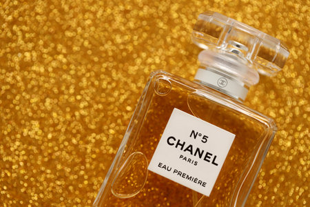 TERNOPIL, UKRAINE - SEPTEMBER 2, 2022 Chanel Number 5 Eau Premiere famous worldwide french perfume bottle on shiny glitter background in golden and yellow colorsのeditorial素材