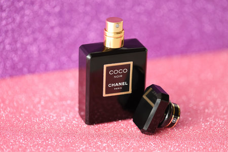 TERNOPIL, UKRAINE - SEPTEMBER 2, 2022 Coco Noir Chanel Paris worldwide famous french perfume black bottle on shiny glitter background in purple and pink colorsのeditorial素材