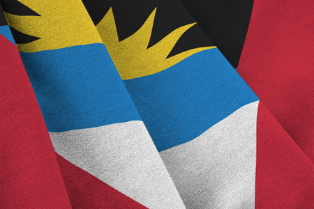 Antigua and Barbuda flag with big folds waving close up under the studio light indoors. The official symbols and colors in fabric bannerの写真素材