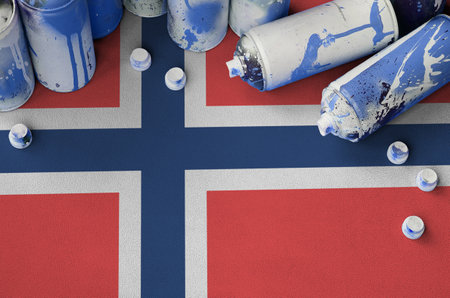 Norway flag and few used aerosol spray cans for graffiti painting. Street art culture concept, vandalism problemsの写真素材