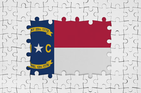North Carolina US state flag in frame of white puzzle pieces with missing central partsの写真素材