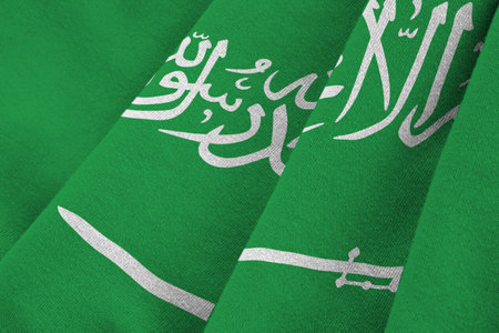 Saudi Arabia flag with big folds waving close up under the studio light indoors. The official symbols and colors in fabric bannerの写真素材