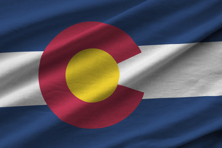 Colorado US state flag with big folds waving close up under the studio light indoors. The official symbols and colors in fabric bannerの写真素材