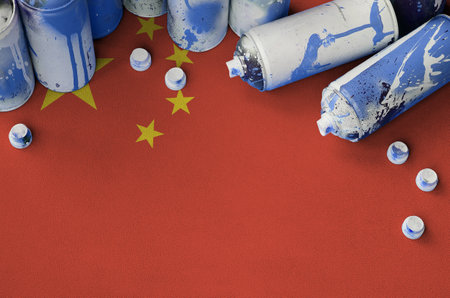 China flag and few used aerosol spray cans for graffiti painting. Street art culture concept,...