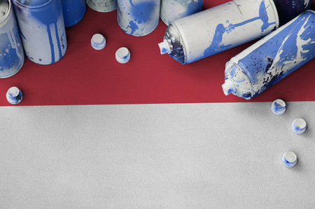 Monaco flag and few used aerosol spray cans for graffiti painting. Street art culture concept, vandalism problemsの写真素材