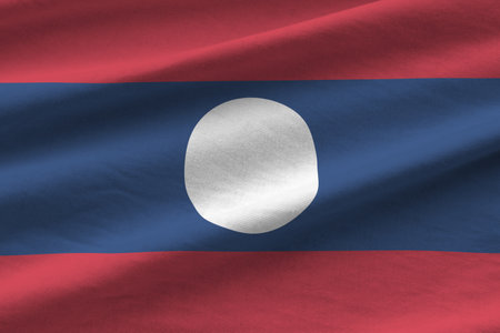 Laos flag with big folds waving close up under the studio light indoors. The official symbols and colors in fabric bannerの写真素材