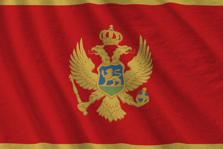 Montenegro flag with big folds waving close up under the studio light indoors. The official symbols and colors in fabric bannerの写真素材