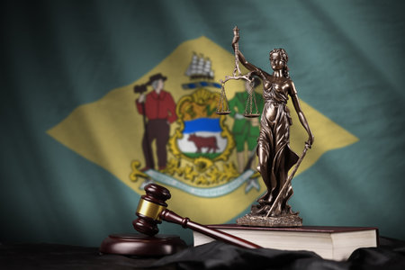 Delaware US state flag with statue of lady justice, constitution and judge hammer on black drapery. Concept of judgment and punishmentの写真素材