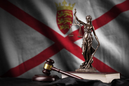Jersey flag with statue of lady justice, constitution and judge hammer on black drapery. Concept of judgement and punishmentの写真素材
