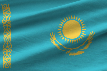 Kazakhstan flag with big folds waving close up under the studio light indoors. The official symbols and colors in fabric bannerの写真素材